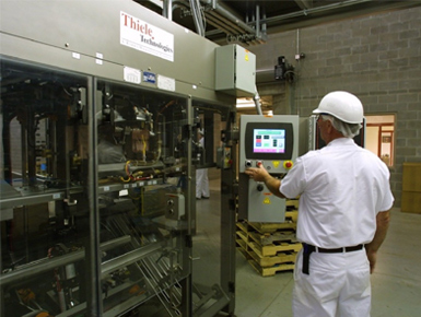 An operator at the HMI of a packaging machine in Natura's Fremont plant