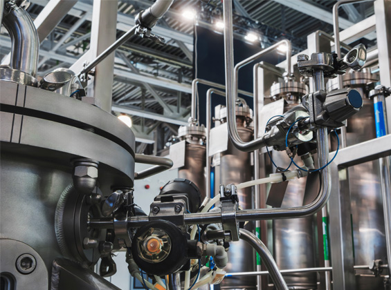 Close-up of a stainless steel process vessel with valves, sensors and sanitary piping